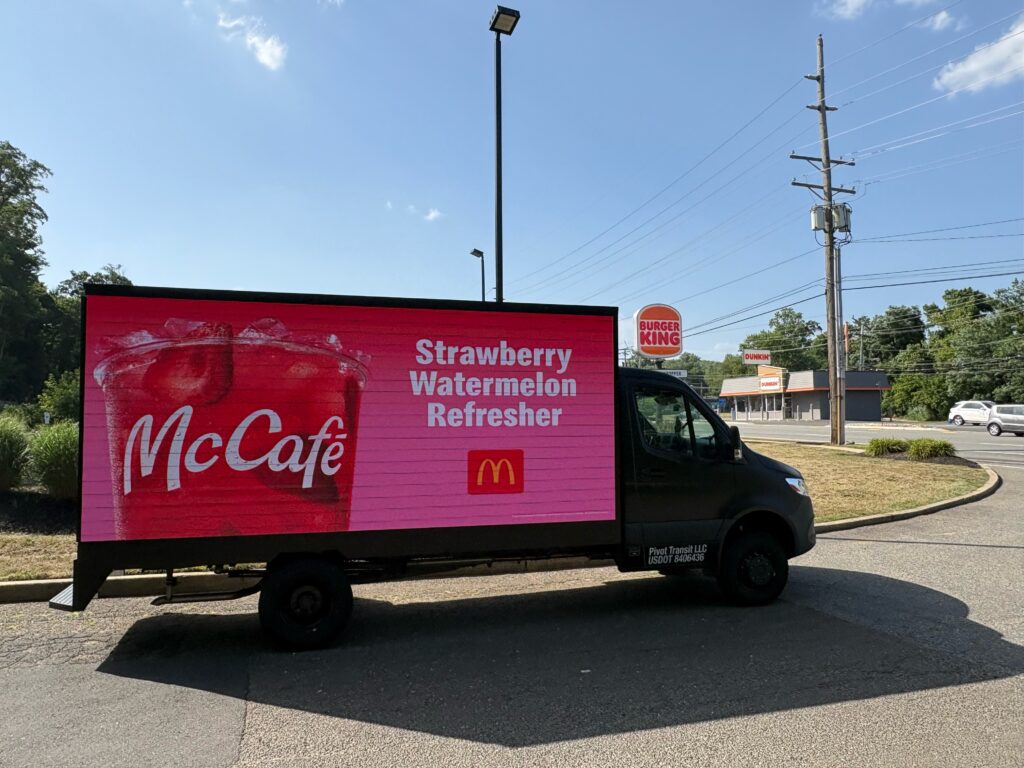 AMMPS mobile billboard truck with a bright digital LED screen driving through downtown Tampa, Florida